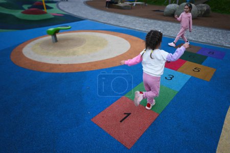 Photo for Little girl playing hopscotch at playground in the park. - Royalty Free Image