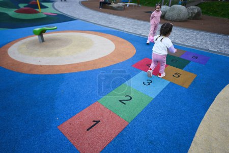 Photo for Little girl playing hopscotch game in park. Early education concept - Royalty Free Image