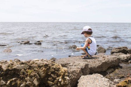 Téléchargez les photos : Enfant regardant la rivière polluée de la rive, concept environnemental - en image libre de droit