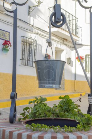Téléchargez les photos : Photographie de puits avec seau dans la rue de la ville - en image libre de droit