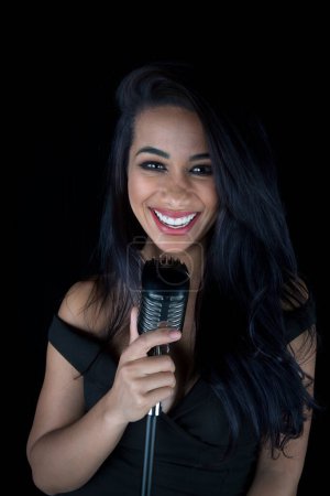 Carismático negro cantante hembra sosteniendo micrófono