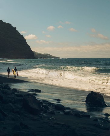Téléchargez les photos : COUPLE DE SURF DANS UNE PLAGE - en image libre de droit