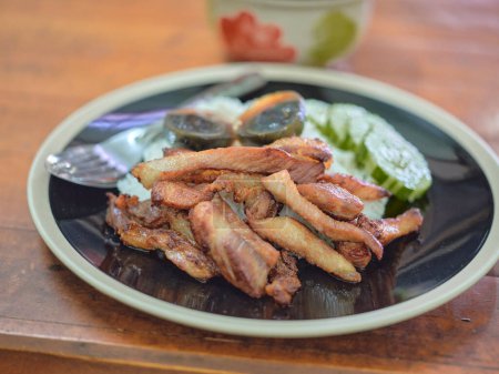 Foto de Vientre de cerdo frito con salsa de pescado, huevo conservado y salsa picante - Imagen libre de derechos
