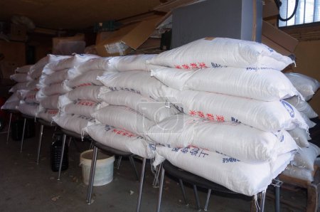 Téléchargez les photos : Occitanie, France - Juin 2022 - Un stock de 20 kg de sacs de riz étiquetés avec des caractères chinois, en dépôt temporaire, importés en Europe d'Asie du Sud-Est, probablement de Thaïlande ou du Cambodge - en image libre de droit