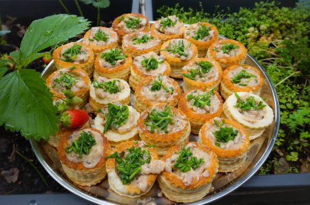 Foto de Plate of artisanal homemade French puff pastry shells (bouches  la reine) ; the dish consists of pastry hollow cases (vol-au-vents) filled with a meat-based garnish - Imagen libre de derechos