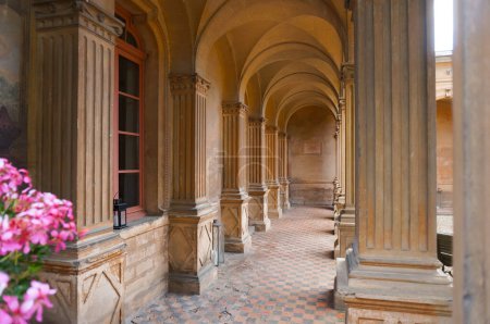Photo for Near Lyon, France - June 2019 - Perspective of the elegant gallery of arcades of the Italian cloister of Saint Trys Castle, having ribbed vaults, sculpted square columns and terracotta tiled floor - Royalty Free Image