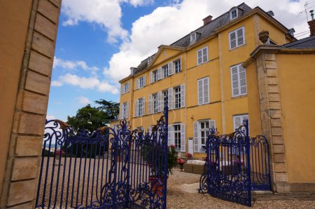 Photo for Near Lyon, France - June 2019 - Yellow facade and outdoor stairs of the Castle of Saint Trys, a 17th-century lordly residence in Beaujolais region, seen from the main courtyard with its gravel soil - Royalty Free Image