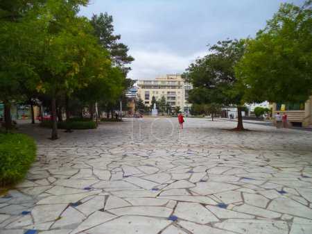 Foto de Pavimento de piedra de la arbolada Plaza Charles de Gaulle, una tranquila zona peatonal bordeada por lujosos edificios de apartamentos en la mundialmente famosa ciudad balneario de Vichy en Francia - Imagen libre de derechos
