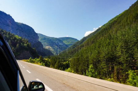 Foto de Impresionante paso de montaña frondoso visto desde un coche en la carretera, en un hermoso paisaje verde, con laderas boscosas y acantilados rocosos en los Alpes-de-Haute-Provence, en los Alpes meridionales de Francia - Imagen libre de derechos