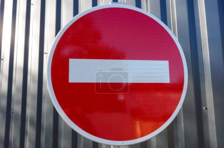 Foto de Señalización vial roja y blanca con superficie reflectante, en Francia: una señal de no entrada, en forma de disco, con fondo de chapa - Imagen libre de derechos