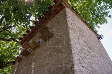 Photo for Pigeon house, pigeonholes of a traditional brick dovecot featuring a tiled roof, in an organic farm in Occitanie, Southern France - Royalty Free Image