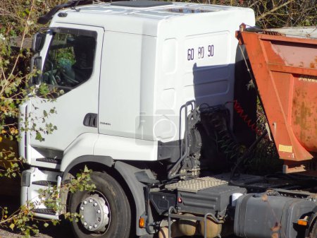 Photo for Occitanie, France - Nov. 2020 - Closer view on a white 4-wheel tractor trailer, made in Europe by the Swedish manufacturer Volvo Trucks, towing a red tipper semi-trailer adapted for road works - Royalty Free Image