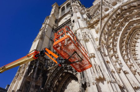 Foto de Troyes, Francia - Sept. 2020 - Vista en ángulo bajo de una plataforma aérea frente a la catedral de Saint-Pierre-et-Saint-Paul, en medio de obras de restauración realizadas en la fachada frontal del monumento gótico - Imagen libre de derechos