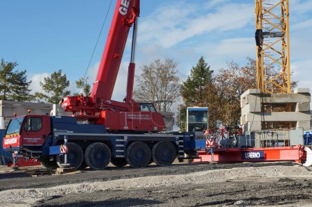 Photo for Reims, France - Nov. 2022 - A red, wheeled mobile crane helps to mount a stationary, tower crane, on a construction site on Moulin de la Housse Science Campus of Reims Champagne-Ardenne University - Royalty Free Image