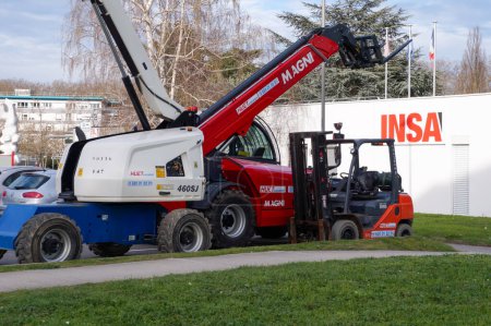 Photo for Toulouse, France - March 2023 - Lifting and handling equipment: a French Manitou telehandler, a forklift-truck and a basket crane (or cherry-picker), parked on INSA campus - Royalty Free Image