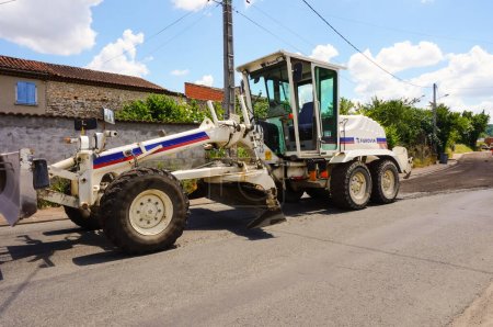 Photo for Tarn, France - May 2020 - A New Holland (CNH) motor grader operated by the French construction company Eurovia (Vinci), featuring two grading blades mounted on the front axle and a back ripper - Royalty Free Image