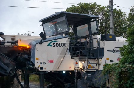 Photo for Albi, France - Aug. 1, 2021 - A cold milling machine for road pavement removal, made by German manufacturer Wirtgen, a leader in construction machinery, here operated by public works company Soloc - Royalty Free Image
