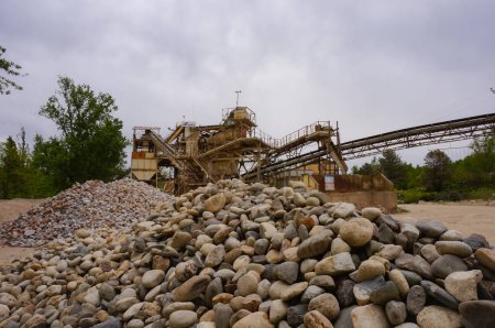Photo for Albi, France - May 2021 - Piles of pebbles in front of a large, old steel machinery at the cement and concrete mixing plant of the Mexican company Cemex, a world leader in building materials - Royalty Free Image