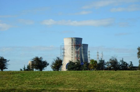 Photo for Pierrelatte, France - Oct. 2021 - Cooling towers and electric pylons of the CNPE, a PWR nuclear power plant run by EDF, located within one of the largest atomic energy technology site worldwide - Royalty Free Image
