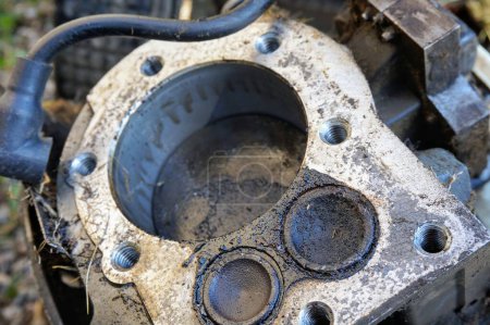 Foto de Detalle de un viejo motor térmico de una cortadora de césped: las válvulas, el cilindro y el pistón en el interior y el cable de conexión para el enchufe - Imagen libre de derechos