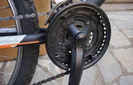 Photo for Detail of the front transmission of a mountain bike and closer view on the crankset mounted on the aluminum frame, with the pedal fixed on the axis and the chain positioned on the third ring - Royalty Free Image