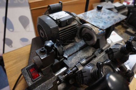 Foto de París, Francia - Sept. 2020 - Una máquina herramienta compleja en el taller de un artesano que trabaja en la industria de calzado o reparación y corte de llaves, con un motor eléctrico y un interruptor de encendido y apagado - Imagen libre de derechos