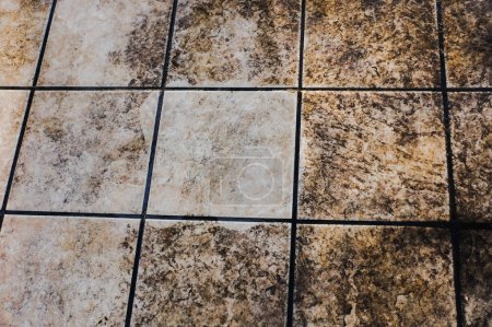 Photo for House maintenance : comparison between the dirty outdoor floor tiles of a terrace and a tile washed and whitened by means of a high-pressure cleaner, with some persistent stains incrusted in the stone - Royalty Free Image