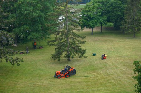 Téléchargez les photos : Reims, France - Juin 2021 - Un jardinier avec le CROUS de Reims sur un tracteur dans le parc d'une résidence étudiante près du campus universitaire Moulin de la Housse, finit de tondre l'herbe - en image libre de droit