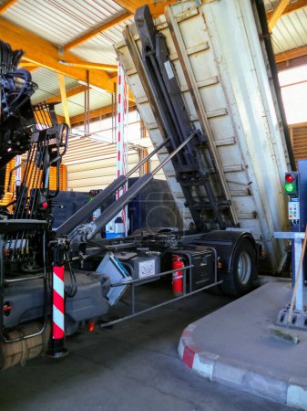 Photo for Albi, France - July 2016 - Dump truck equipped with a crane, unloading its removable bucket thanks to hydraulic cylindersl at the waste facility of Ranteil operated by the Urban Community of Albi - Royalty Free Image