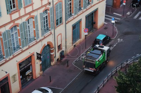 Photo for Toulouse, France - July 2020 - Top view at early morning above a technical vehicle of the urban cleaning service of the Mtropole (the local authority), cleaning up the street of Place des Carmes - Royalty Free Image