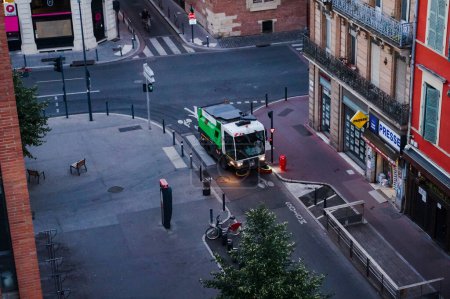 Téléchargez les photos : Toulouse, France - Juillet 2020 - Vue de dessus tôt le matin au-dessus d'un véhicule technique du service de nettoyage urbain du Mtropole, nettoyant la rue de la Place des Carmes - en image libre de droit