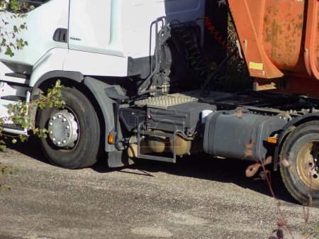 Photo for Occitanie, France - Nov. 2020 - Closer view on a white 4-wheel tractor trailer, made in Europe by the Swedish manufacturer Volvo Trucks, towing a red tipper semi-trailer adapted for road works - Royalty Free Image