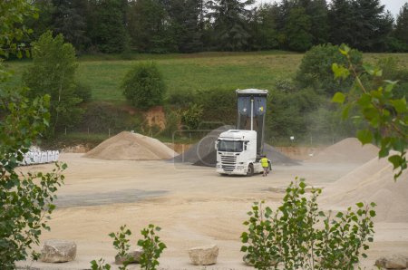 Photo for Albi, France - April 2021 - A Scania tipper semi trailer dumps a load of gravel in a quarry, at a concrete plant run by the Mexican company Cemex, a world leader in the construction industry - Royalty Free Image