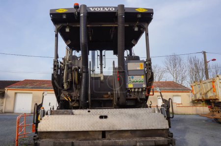 Photo for Villefranche d'Albigeois, France - Feb. 2021 - Back of the operator's cabin of an ABG asphalt paver, manufactured by the Swedish company Volvo, on a car park; the machine features two exhaust pipes - Royalty Free Image