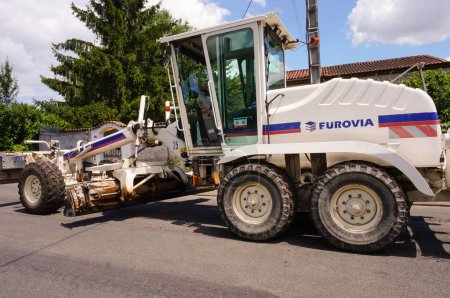 Photo for Tarn, France - May 2020 - Rear view of a New Holland motor grader operated by the French construction company Eurovia (Vinci), featuring two grading blades mounted on the front axle and a back ripper - Royalty Free Image