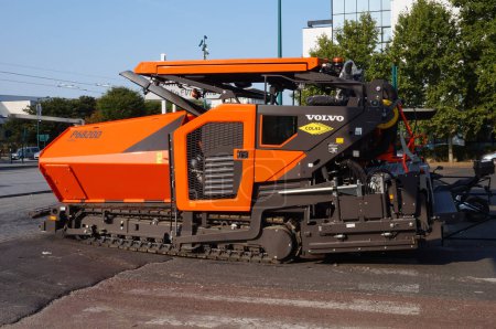 Foto de Gennevilliers, Francia - Sept. 2020 - Una pavimentadora de asfalto P6820D ABG naranja, fabricada por la empresa sueca Volvo y operada por el grupo constructor francés Colas (Bouygues) - Imagen libre de derechos