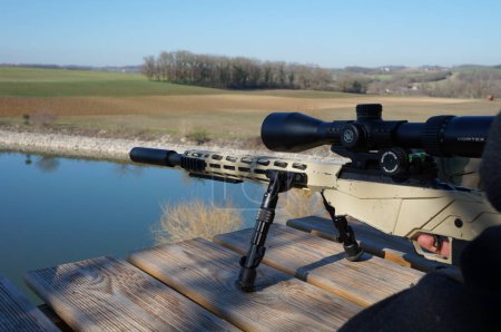 Photo for Occitanie, France - Feb. 2023 - A Ruger Precision Rimfire, a carbin firing .22 LR Winchester cartridges, mounted on a bipod, on a shotting platform that dominates a vast, countryside outdoor range - Royalty Free Image