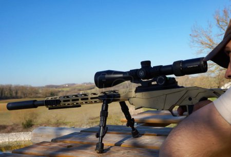 Photo for Occitanie, France - Feb. 2023 - A sniper aims at his target thanks to a gunsight on his Ruger Precision Rimfire, a bolt-action carbin made in the USA, designed to chamber .22 LR ammunition - Royalty Free Image