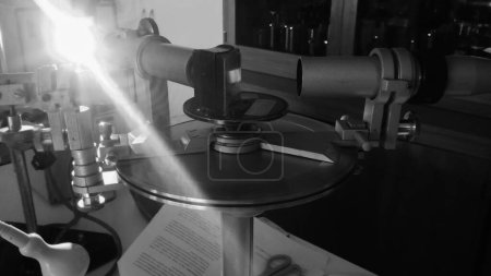 Téléchargez les photos : Matériau expérimental d'un laboratoire d'optique à Toulouse, France : un goniomètre à prisme de verre pour l'analyse spectrale, doté de scopes autocollimateurs et nonius, éclairé avec une lampe à sodium - en image libre de droit