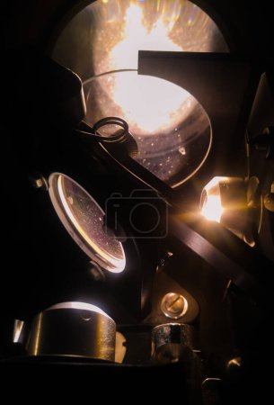 Téléchargez les photos : Expérience scientifique de physique dans l'obscurité : miroirs, lentilles de précision et mécanique de vol d'un interféromètre Michelson fabriqué au Japon dans un laboratoire français d'optique ondulatoire, utilisé en lumière blanche - en image libre de droit