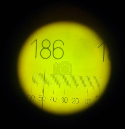 Foto de Toulouse, Francia - Junio 2020 - Visor óptico de un refractómetro: en el visor, un cursor se mueve por encima de una escala graduada, retroiluminado con luz verde, lo que permite medir el índice de refracción - Imagen libre de derechos