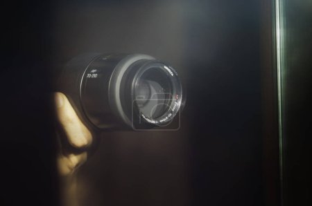 Foto de Tarn, Francia - Feb. 2020 - Imagen borrosa y duplicada en un espejo del objetivo de una cámara híbrida Sony, sostenida en las manos del fotógrafo, con problemas debido a la luz del flash - Imagen libre de derechos