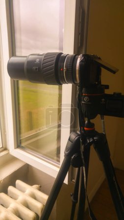 Foto de Tarn, Francia - Feb. 2020 - Equipo de fabricación japonesa de un fotógrafo, montado en un trípode estabilizador: una lente de longitud focal larga Konica Minolta (teleobjetivo), fijada a una cámara híbrida Sony Alpha NEX - Imagen libre de derechos