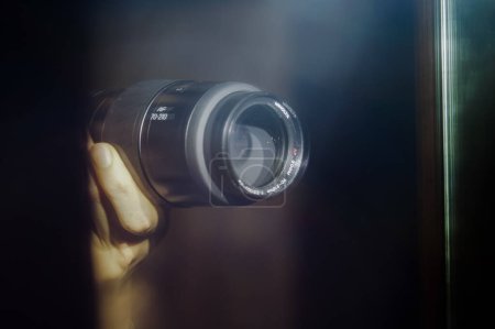 Foto de Tarn, Francia - Feb. 2020 - Imagen borrosa y duplicada en un espejo del objetivo de una cámara híbrida Sony, sostenida en las manos del fotógrafo, con problemas debido a la luz del flash - Imagen libre de derechos