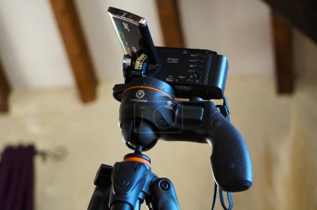 Foto de Crest, Francia - 1 de octubre de 2021 - Un maintream de luz negra, una cámara de video japonesa JVC, con pantalla giratoria y batería, montada en un trípode de vanguardia chino ajustable con rótula y pistola - Imagen libre de derechos