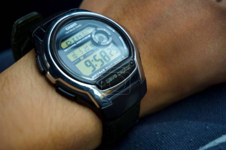 Téléchargez les photos : Tarn, France - Juillet 2018 - Une montre électronique de la série Wave Ceptor, par le fabricant japonais Casio, sur le poignet d'un homme ; le modèle est synchronisé par signal radio à l'heure du monde atomique - en image libre de droit
