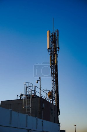 Téléchargez les photos : Pylône en acier de l'antenne de télécommunication de la tour cellulaire installée au sommet du parking de Carmes, qui domine la ville de Toulouse en France, dans un fond bleu foncé au lever du soleil - en image libre de droit