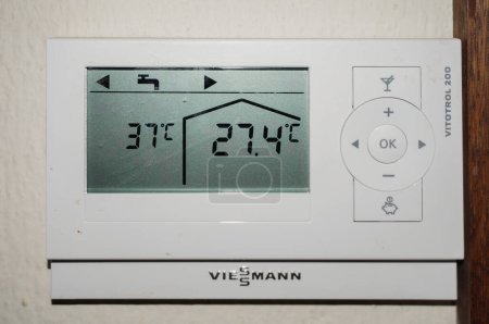 Foto de Temperaturas caniculares de verano (99F exterior, 81F interior) exhibidas en la pantalla del termostato de un sistema de calefacción central de diseño alemán, registrado en Tarn, sur de Francia, en agosto de 2020 - Imagen libre de derechos
