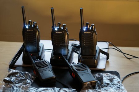 Téléchargez les photos : Occitanie, France - Décembre 2021 - Quelques forces de police de matériel de survie : une station de radio avec plusieurs talkies-walkies sur leurs quais de chargement, des lampes flash en métal, et une boussole avec un étui doré - en image libre de droit