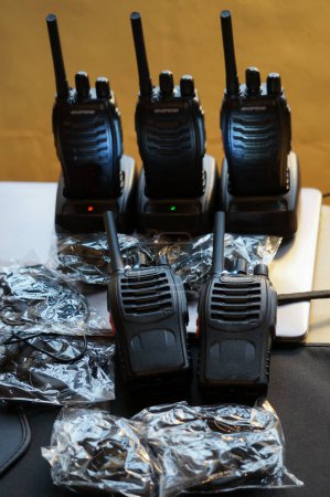 Foto de Occitanie, Francia - Dic. 2021 - Una moderna estación de radio, compuesta por varios walkie-talkies del fabricante electrónico chino Baofeng, con auriculares aún no desenvueltos de sus envases - Imagen libre de derechos